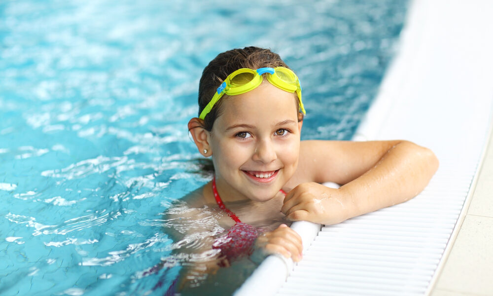 Girl with goggles in swimming pool